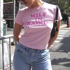 "'MILF In Training' Cropped Y2K Baby Tee cuz the future is close. This crop top that has a slim fit construction, a crew neckline, short sleeves, and a \"MILF In Training\" graphic on the front. 🦋Dispatch Within 3 Days 🦋 🌸 Free Delivery To Most Countries 🌸 🧿The Best Trending Fashion 🧿 PLEASE REFER TO THE SIZE CHART ON THE LAST IMAGE OF THIS LISTING BEFORE PURCHASING. **PLEASE NOTE THIS IS A BABY CROP T-SHIRT, PLEASE SEE STOCK IMAGE FOR ACCURATE LENGH** PLEASE CHECK THE STOCK IMAGES ON THE Summer Cropped Top, Y2k Outfit Ideas, Shapewear Dress, Pose Fotografi, Baby Tees Y2k, Pink Y2k, Short Sleeve Bodycon Dress, Streetwear Tops