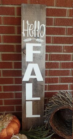 a wooden sign that says fall on it next to some pumpkins and other decorations