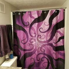 a bathroom with a purple shower curtain in it