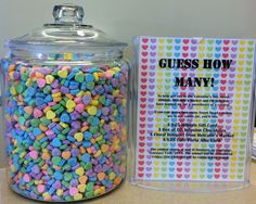 a glass jar filled with lots of candy next to a sign that says guess how many