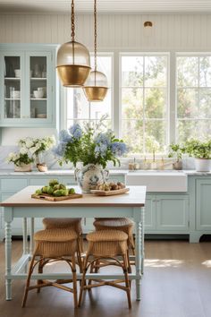 a kitchen with blue cabinets and white counter tops, two stools at the island