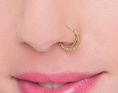 a close up of a woman's nose with a gold nose ring on it