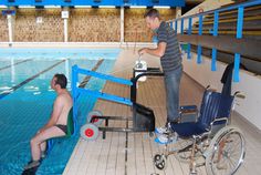 a man in a wheelchair next to an empty swimming pool while another man stands near the edge