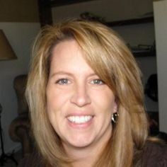 a woman with blonde hair is smiling for the camera while wearing a black shirt and earrings