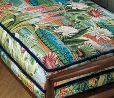 a close up of a footstool on a wooden floor with flowers and leaves