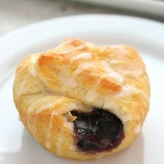 two blueberry pastries sitting on top of a white plate