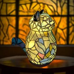 a stained glass squirrel lamp sitting on top of a table