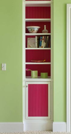 a white bookcase with pink and green accents