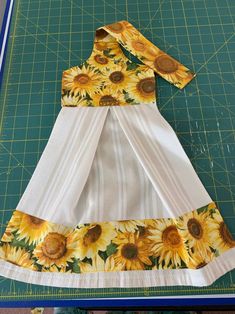 a sunflower dress made out of fabric on a cutting board