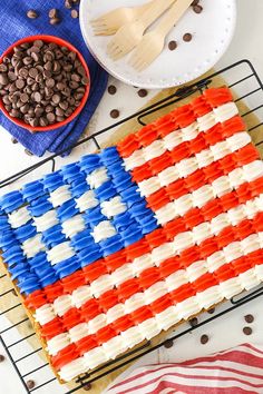 an american flag cake on a cooling rack with chocolate chips and coffee beans next to it