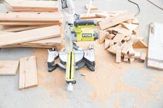 a table saw sitting on top of wooden planks next to a pile of wood