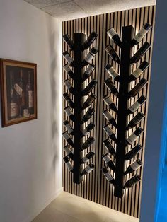 a wine rack in the corner of a room next to a wall with pictures on it