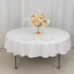 a white table with flowers and two wine glasses on it