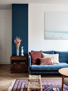 a living room with blue couches and rugs on the hardwood floored floor