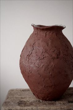 a brown vase sitting on top of a wooden table