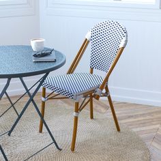 a blue table with two chairs next to it and a white cup on the side