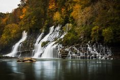 a large waterfall in the middle of a forest