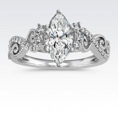 a white gold engagement ring with an oval cut diamond surrounded by small round brilliant diamonds