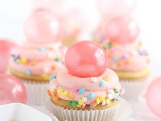 some cupcakes with pink frosting and sprinkles