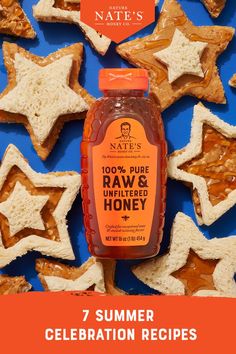 a bottle of raw and unfilled honey next to some star shaped cookies on a blue background