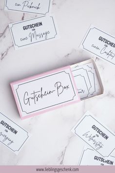 a pink and white box with some writing on it next to other labels that read gutschen - box