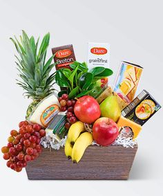 a wooden box filled with assorted fruit and cheese on top of a white background