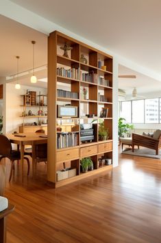 a living room filled with lots of furniture and bookshelves next to a window