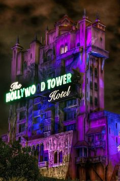 the hollywood d'tower hotel is lit up in purple and green for night time