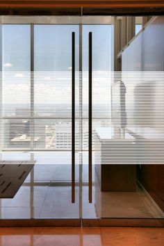 an empty room with glass walls and floor to ceiling windows overlooking the cityscape