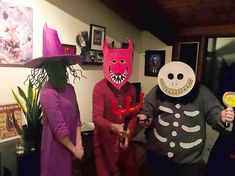 three people in halloween costumes standing next to each other