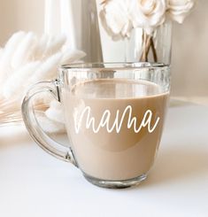 there is a glass cup that has coffee in it and the word mama written on it