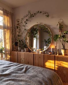 a bedroom with plants on the wall and a round mirror