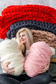 a woman is sitting on the floor with some yarn