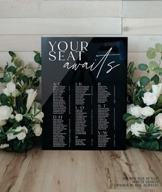 a black and white wedding seating chart with flowers on the table next to each other