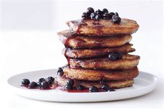 a stack of pancakes with blueberries and syrup