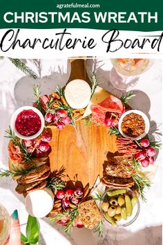 a christmas wreath made out of cheese, meats and fruit on a wooden board