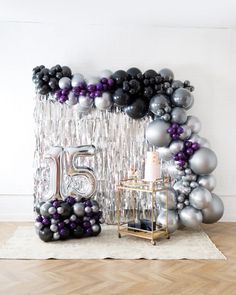 the balloon arch is decorated with silver and black balloons, which spell out the number twenty five