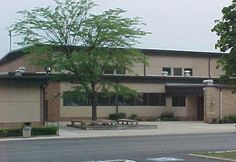 an outside view of a building with trees and benches