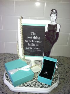 an image of a woman's gift set up on a counter with a sign and jewelry