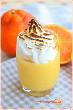 an orange dessert in a small glass with whipped cream