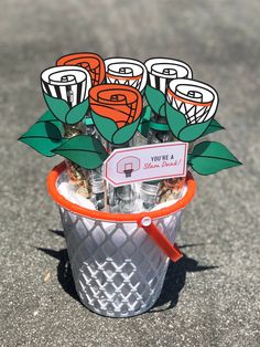 a basket filled with lots of candy sitting on top of a cement floor next to a sign