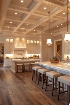 a large kitchen with white cabinets and counter tops, an island in the middle is surrounded by stools