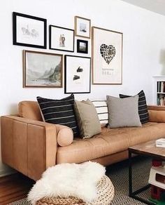 a living room with pictures on the wall and a couch in front of some coffee tables