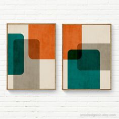 two framed art pieces on a brick wall, each with an orange and green geometric design