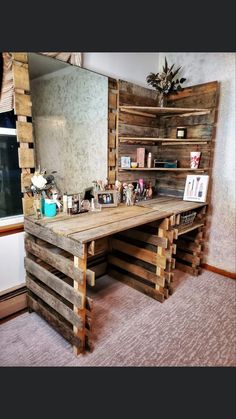 a desk made out of wooden pallets in front of a large mirror and shelves