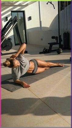 a woman laying on the ground in front of a gym machine