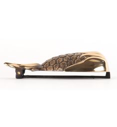 a brass whale figurine on a white background