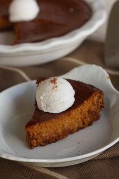 there is a piece of pie on the plate with ice cream on top and another slice in the background