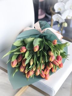 a bouquet of tulips sitting on top of a white chair