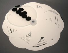 four white round coasters with black circles on them